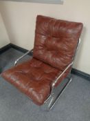 A mid 20th century Danish tubular metal armchair with brown buttoned leather cushions