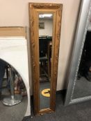 A contemporary golden framed mirror 27 x 122 cm