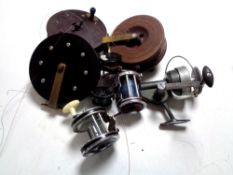 A vintage wooden handled landing net together with a canvas bag containing assorted reels to