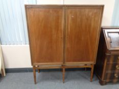 A mid 20th century double door cabinet on raised legs
