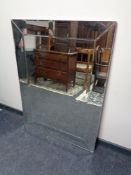 A contemporary all glass mirror framed bevel edged mirror