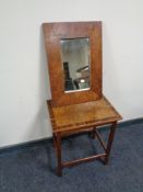A walnut veneered occasional table and a wall mirror,