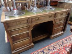 A 19th century oak twin pedestal desk fitted nine drawers with a green tooled leather inset panel