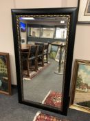 A contemporary black framed mirror 79 x 140 cm