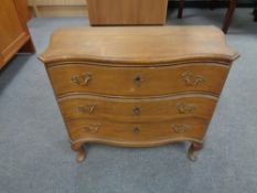 A 20th century oak serpentine fronted three drawer chest on Queen Anne legs