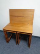 A 20th century G-Plan nest of three teak tables comprising of turnover top table fitted two beneath