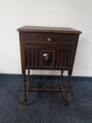 An Edwardian oak smoker's cabinet on raised barley twist legs
