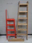 Two sets of folding wooden steps together with a wooden vice