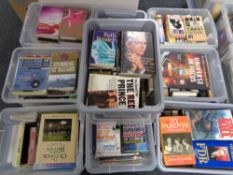 A pallet containing nine plastic storage boxes with lids containing books,