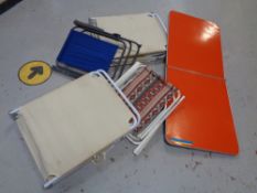 A folding camping table together with two folding loungers and two folding chairs