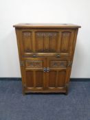 A Priory Oak linen fold cocktail cabinet,