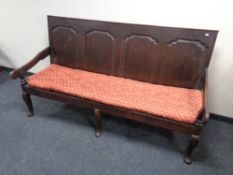 A 19th century oak panel back hall settee