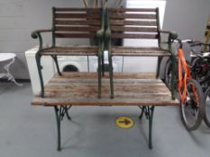 A cast iron wooden slatted garden bench with matching pair of armchairs