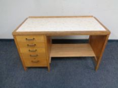 A 20th century single pedestal five drawer chest with inset panel top