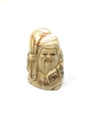 A carved Chinese bone netsuke - Village elder holding a sack