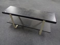 A contemporary black ash two tier stand on metal supports