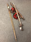 A Sudanese kaskara sword in scabbard, together with two tribal fish spears.
