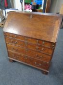 A 19th century oak bureau fitted four drawers beneath with brass drop handles