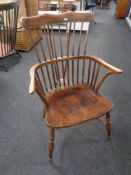 An antique stick back kitchen armchair