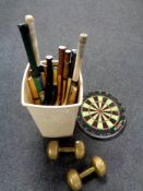 A plastic bin containing a large quantity of sports rackets, cricket bats,