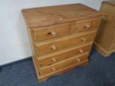 A stripped pine five drawer chest