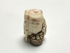 A carved Chinese bone netsuke - Gentleman holding a basket