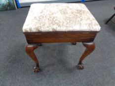 An Edwardian mahogany storage piano stool on claw and ball feet