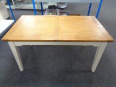 A contemporary pine topped extending dining table on painted legs