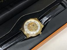 A gent's Stuhrling gold plated automatic wristwatch with visible movement, boxed.