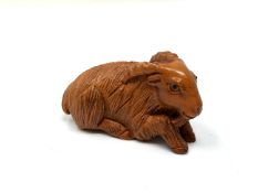 A carved Chinese hardwood netsuke - Goat lying down