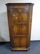 A panelled oak standing corner cupboard