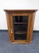 A glazed oak hanging corner cabinet