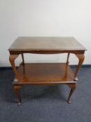 Two walnut coffee tables on pad feet
