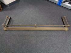 An antique brass fire curb