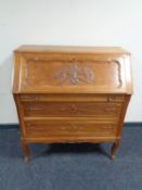 A 20th century continental carved oak bureau