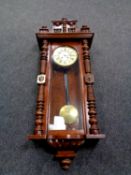 An early 20th century mahogany cased Vienna style eight day wall clock with pendulum and key