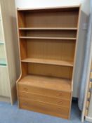 A set of mid 20th century teak effect open bookshelves fitted three drawers beneath