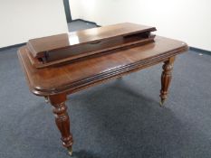 A Victorian style mahogany wind out dining table with two leaves