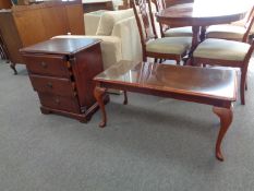 A three drawer chest and a rectangular glass topped coffee table