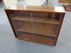 A teak sliding book low bookcase