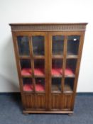 An early 20th century oak linen fold display cabinet