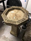 A concrete bird bath together with a concrete figure of a girl and further gilt figure depicting a