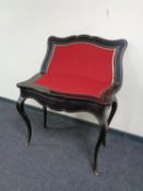 A contemporary black and gilt turnover top card table