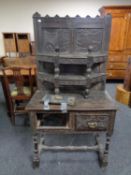 A carved stained oak side table fitted two drawers