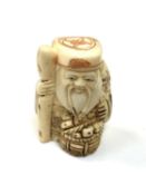 A carved Chinese bone netsuke - Village elder holding a staff