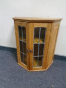 A blonde oak leaded glass door wall cabinet
