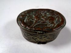 An antique embossed plated snuff box depicting figure on horseback
