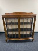 An Edwardian mahogany bow fronted double door display cabinet on claw and ball feet