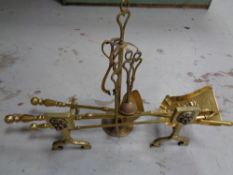 A pair of antique brass fire dogs together with three companion pieces,