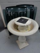 Two folding plastic garden lounger armchairs together with a bird bath